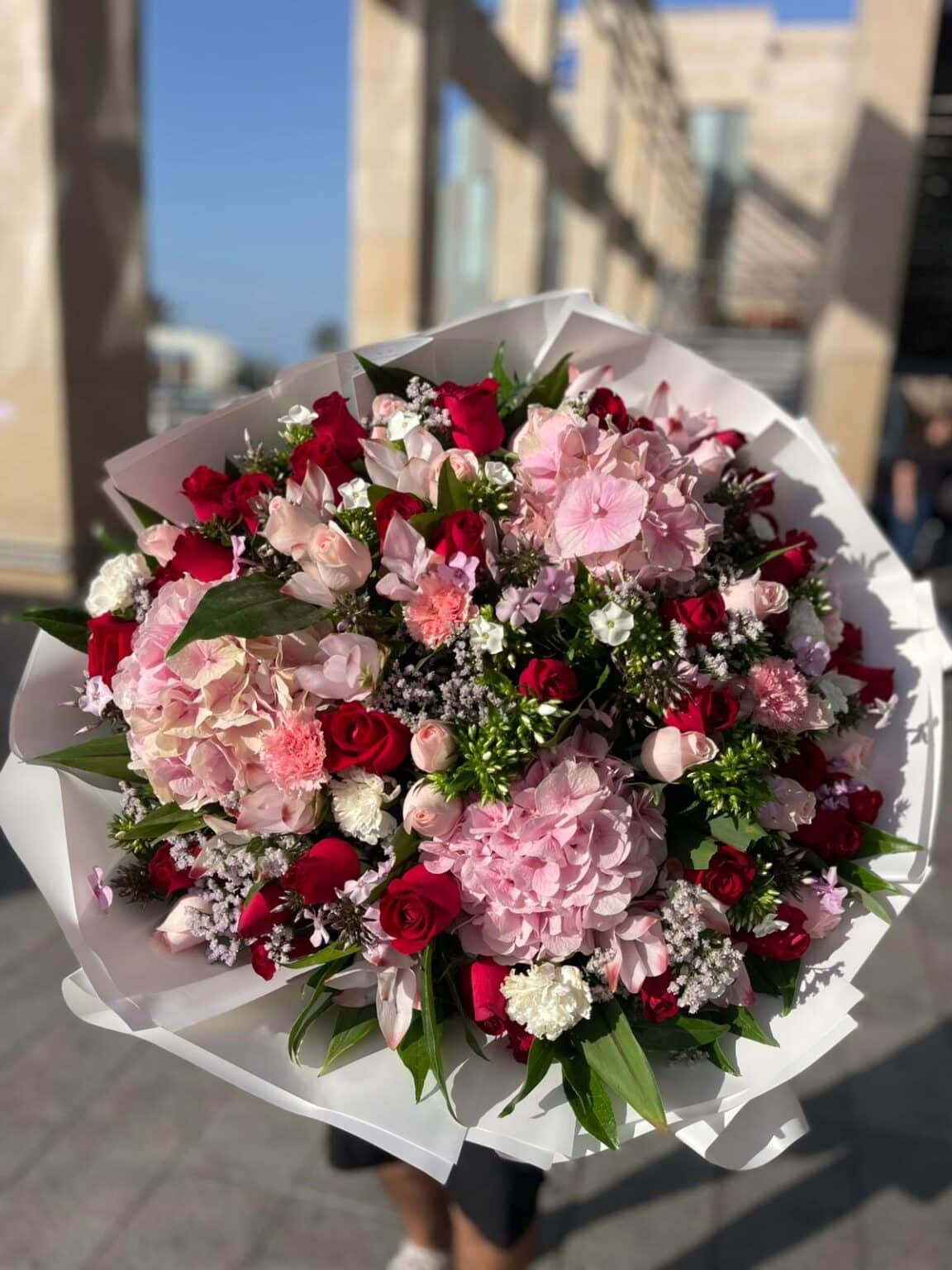 זר הורטנזיות ורודות בשילוב ורדים אדומים, ורדים ורודים ופרחי העונה